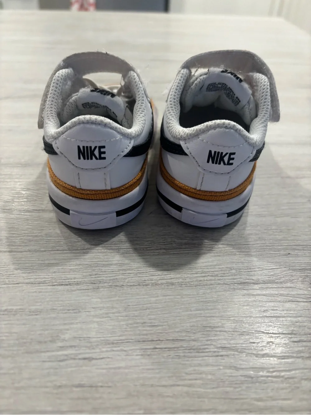 Nike Kids White Sneakers with Black Swoosh and Brown Trim